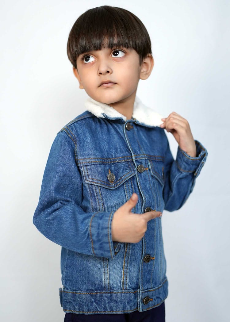 Kid wearing a playful mid blue denim jacket with a cozy collar, showcasing stylish design and comfort.