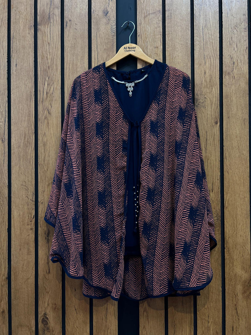 Chic women's patterned kimono-style top hanging on a wooden background